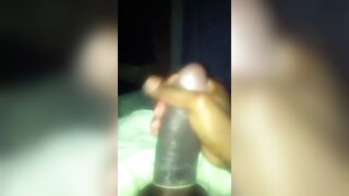 black strokes his huge fat cock with the condom on