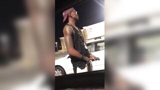 Black thug pissing and rubbing his cock in a parking lot